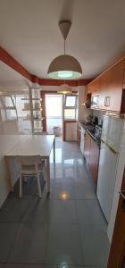波尔图Azulejos Apartment的厨房配有桌子、冰箱和桌子