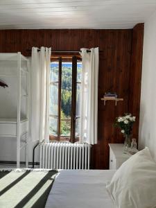 莱德萨阿尔卑斯本艾克尔酒店的一间卧室设有一张床和一个窗口