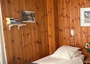 莱德萨阿尔卑斯本艾克尔酒店的一间卧室设有一张床和木墙