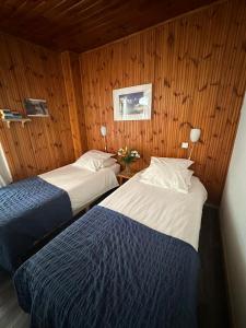 莱德萨阿尔卑斯本艾克尔酒店的木镶板客房内的两张床