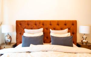 利耶帕亚Design apartment的一张带橙色床头板和枕头的床