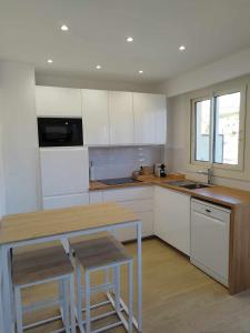 芒通Appartement moderne refait à neuf - 4 couchages - MENTON的厨房配有白色橱柜和木制台面
