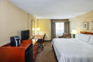 拉瓦尔拉瓦尔蒙特利尔假日酒店的配有一张床和一张书桌的酒店客房