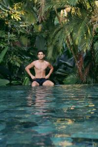 曼努埃尔安东尼奥The Falls at Manuel Antonio的坐在游泳池里的男人