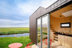 卡罗利嫩西尔Tiny House Nature 14 Zur Meerseite - Green Tiny Village Harlesiel的河景度假屋