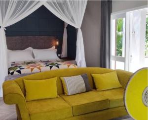 利隆圭Green Elephant的卧室里一张黄色的沙发,卧室里配有一张床