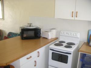 杰弗里湾Waterside Living CL16的厨房配有炉灶和微波炉。