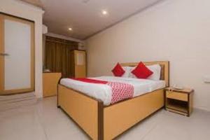 孟买HOTEL ORBITINN MALAD的一间卧室配有红色枕头的床
