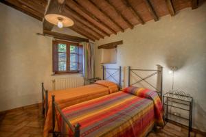 PariAgriturismo Antico Borgo Montacuto的一间卧室设有两张床和窗户。
