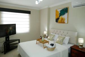 瓜亚基尔Vacation Family Dept 2 Via Costa American Consulate的客厅配有白色的床和电视