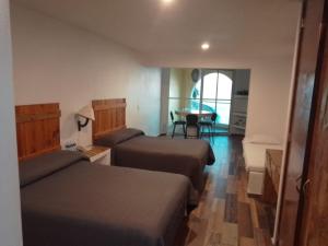 曼萨尼约埃斯孔迪多酒店的酒店客房设有两张床和一张桌子。