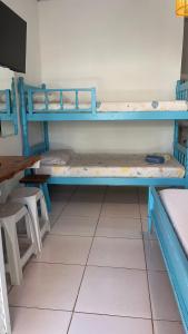 瓜鲁雅Pousada Suítes Sete Mares的客房设有两张双层床和一张桌子。