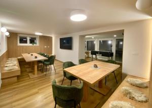莫斯特拉纳Apartments Triglav的一间带2张桌子和钢琴的用餐室