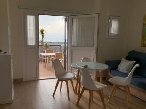 圣玛丽亚港Apartamento La Vasca的一间带桌椅的客厅和一个阳台