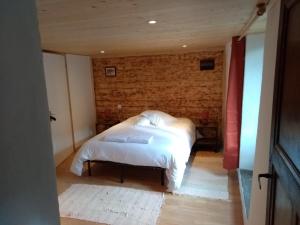 La CabanasseLa Maison Bleue的一间卧室配有带白色床单和枕头的床。