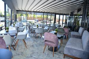 卡萨布兰卡Privilège Oasis Hôtel的餐厅设有桌椅和窗户。