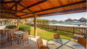福塔莱萨Dom Pedro Laguna Beach Resort & Golf的一个带桌椅的庭院,享有海滩美景