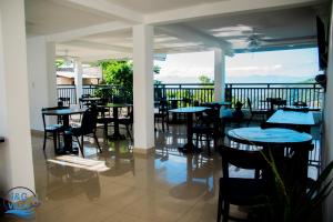 海地角J&G Villa Hotel的阳台餐厅,配有桌椅