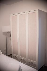 巴亚马雷Maria's Premium Suite的卧室配有白色橱柜和1张床。