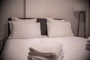 巴亚马雷Maria's Premium Suite的一张带白色床单和枕头的床,配有毛巾