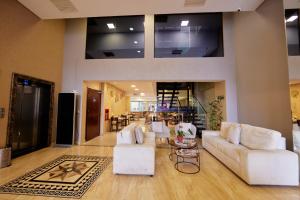 埃斯特城Howard Johnson Ciudad del Este的客厅配有白色的沙发和桌子