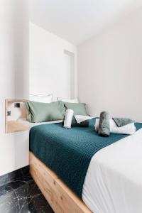 希农Le 107Chinon的一间卧室配有一张带绿色和白色床单的大床