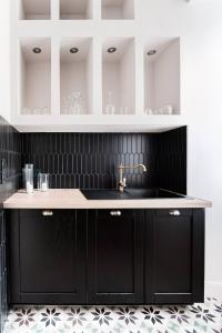 希农Le 107Chinon的厨房配有黑色橱柜和水槽