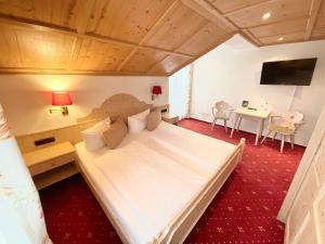 上罗伊特Hotel JMS Holiday Allgäu的一间卧室配有一张大床和一张桌子