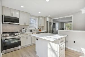 赫恩登Luxury 3 BR Single Family Home - Half acre lot的厨房配有白色橱柜和炉灶烤箱。