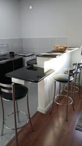约恩维利RCM Vilas - Studio 103 Deluxe的厨房配有带凳子的柜台