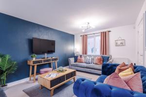 特伦特河畔斯托克Beautiful Stoke Home Sleeps 10 by PureStay Short Lets的蓝色的客厅配有沙发和电视