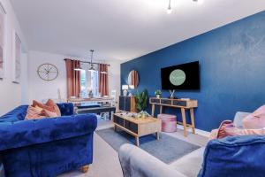 特伦特河畔斯托克Beautiful Stoke Home Sleeps 10 by PureStay Short Lets的客厅配有2把蓝色椅子和蓝色墙壁