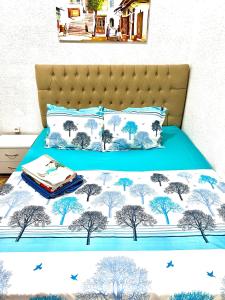 突尼斯Un studio au centre ville de Tunis的一张有蓝色床罩的床,上面有树木