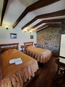 波托西Hotel Santa Mónica的一间卧室设有两张床和石墙