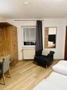 Rodalben绿色花环博德餐厅酒店的一间卧室配有一张床、一把椅子和镜子