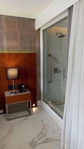 里约热内卢Hotel Nacional的带淋浴的浴室和带台灯的桌子
