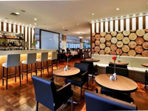 圣保罗M-Flat II Hotel - Vila Olimpia的一间带桌椅的餐厅和一间酒吧
