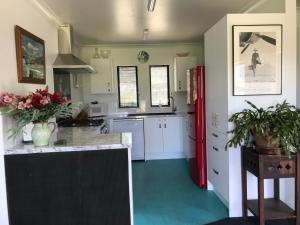 汉默温泉Woodbank Road Escape的厨房配有白色橱柜和红色冰箱