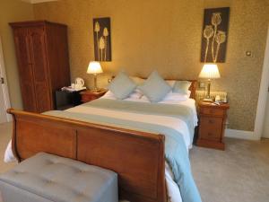 特拉利溪流庄园酒店的一间卧室设有一张大床和两个床头柜