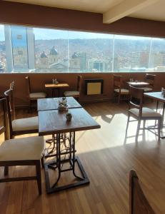 拉巴斯Hotel Madrid的餐厅设有桌椅和大窗户。