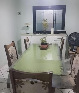 波多韦柳Pousada Souza Familiar的一间带绿色桌椅的用餐室