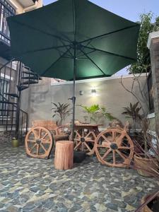 General TriasLa Maison De Rouch - Lancaster的绿色雨伞和木可可桌子