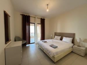 索瓦马E13 Samarah Resort Apartment的一间卧室设有一张大床和一个窗户。