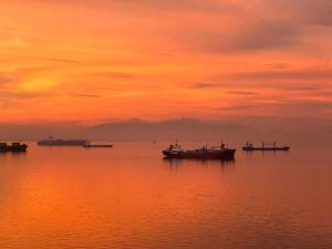 塞萨洛尼基ICONIC SALONICA SUITE seafront的日落时分在水中的小船