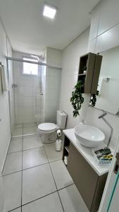 伊塔佩马Condomínio Vista Atlântico - Apartamento Novo - Próximo à Praia - Vista Mar - Área de Lazer的白色的浴室设有卫生间和水槽。