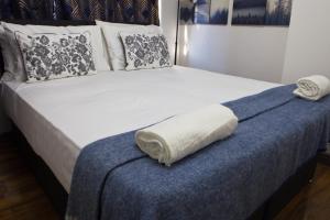 Hatch EndSleek 3Bed/3Bathroom Flat@Harrow的一张床,床尾有一条毛巾