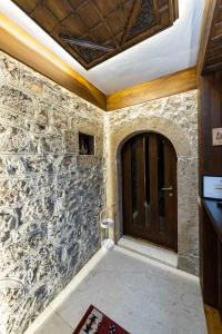 佩奇Hotel - Kulla e Zenel Beut的一间房间内的石墙,有门