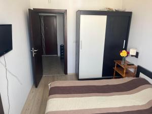 希萨里亚Апартамент Панорама的一间卧室配有一张床,另一扇门配有电视