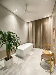 伊瓦格FR Hotel的带浴缸、植物和椅子的浴室