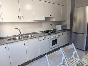 帕拉斯德丽图里斯提克吉列尔莫公寓的厨房配有白色橱柜、水槽和冰箱。